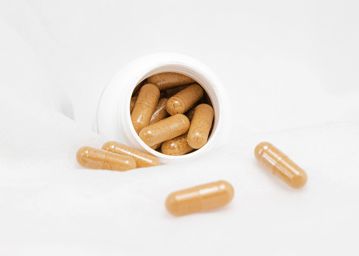 Supplement capsules spilling from a bottle - health and wellness