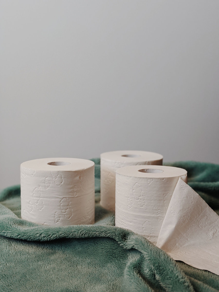 Toilet paper rolls on a green towel - household essentials