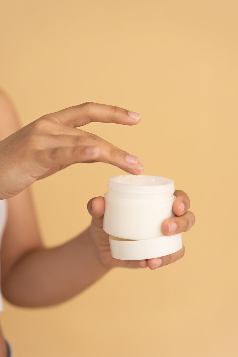 Hand opening a skincare cream jar - personal care